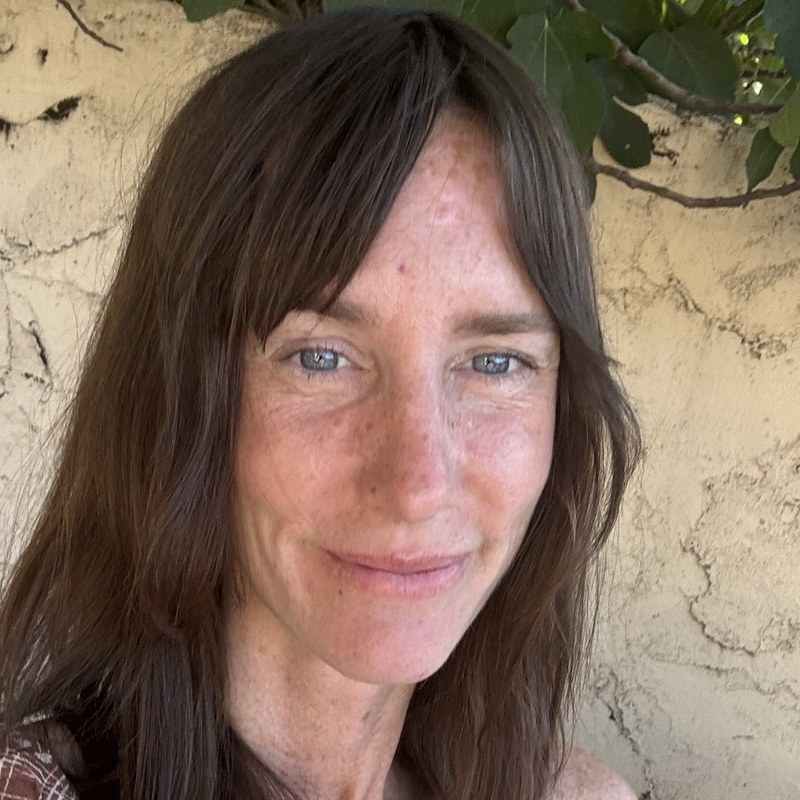 Caley smiling under a fig tree